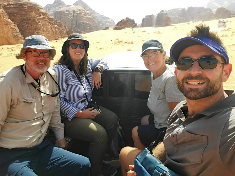 Four travellers sit in the back of a pickup truck in Wadi Rum: The Ancient Cities, Vast Deserts, and Salty Seas of Jordan